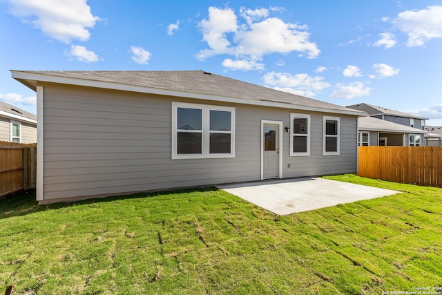 rear view of property featuring a yard and a patio area