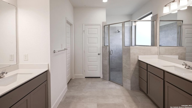 bathroom with tile patterned flooring, vanity, and a shower with door