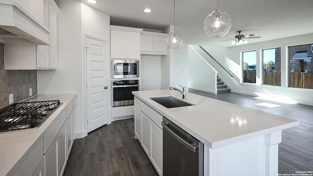 kitchen with sink, stainless steel appliances, an island with sink, white cabinets, and custom range hood