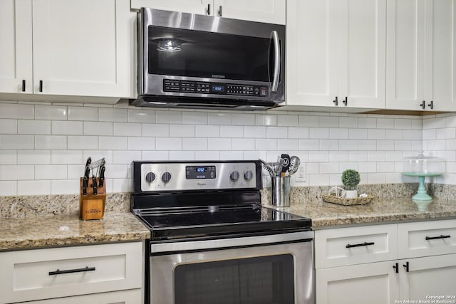 kitchen with light stone countertops, stainless steel appliances, and white cabinetry