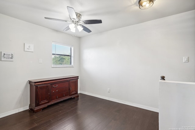 spare room with dark hardwood / wood-style flooring and ceiling fan