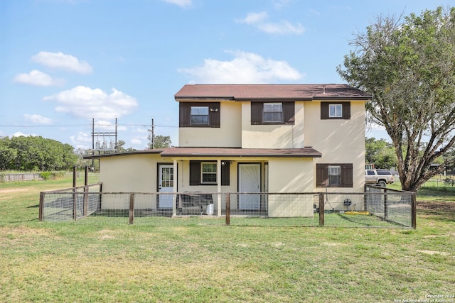 rear view of house featuring a lawn