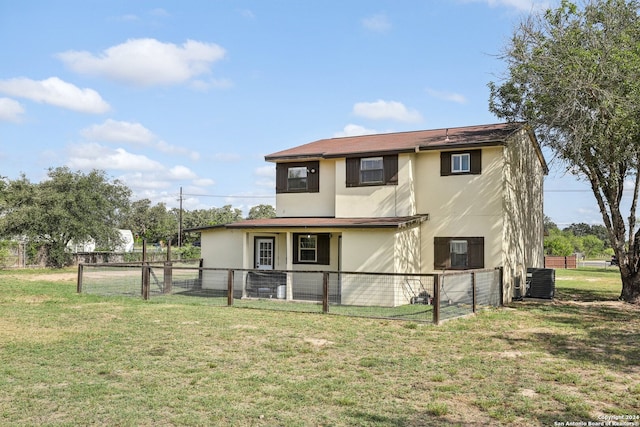 back of property featuring central AC unit and a yard