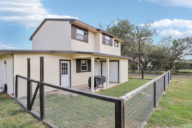 rear view of property featuring a lawn