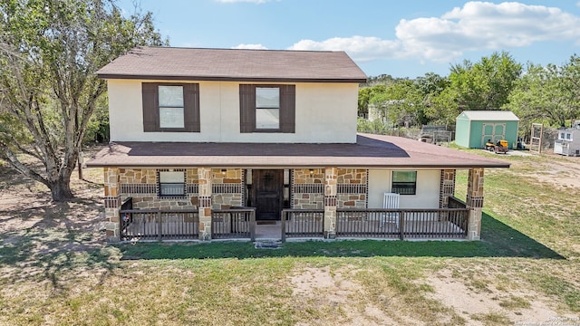 view of front of property with a storage shed, a front lawn, and a patio area