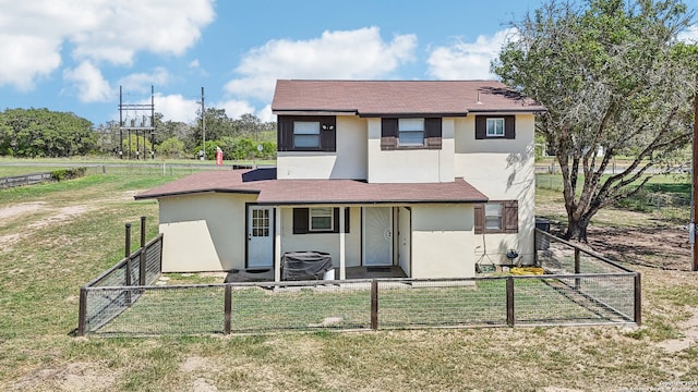 rear view of property featuring a yard