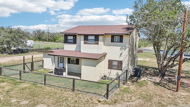 back of property featuring a lawn and central AC