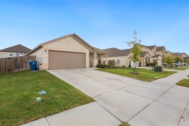 ranch-style house featuring a garage, central air condition unit, and a front yard