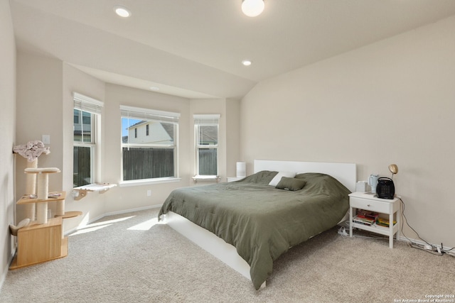 bedroom featuring light carpet and lofted ceiling