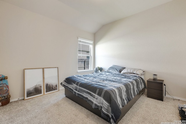 carpeted bedroom with lofted ceiling