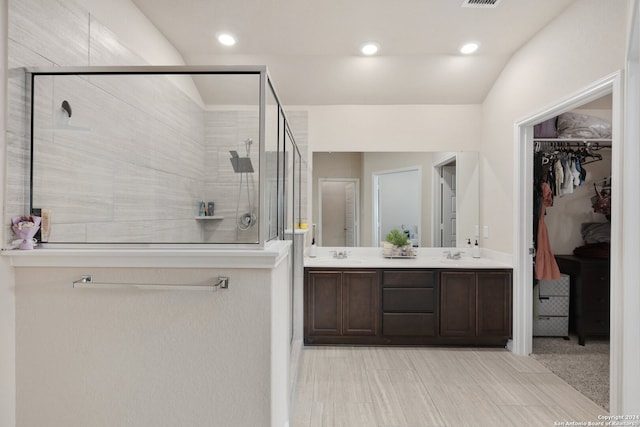 bathroom featuring lofted ceiling, a shower with door, and vanity