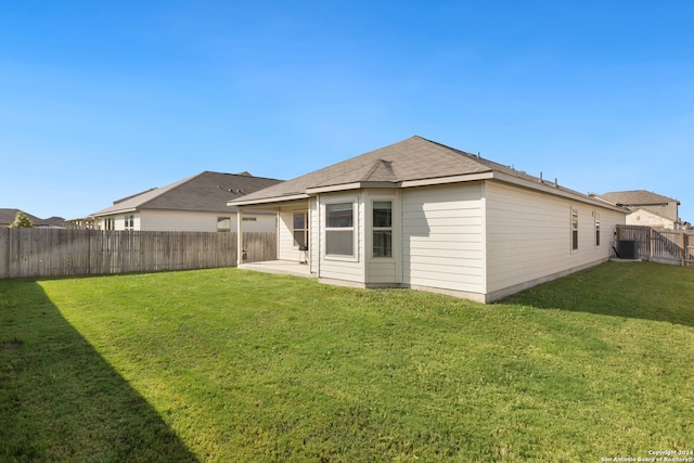 rear view of house featuring a yard, a patio, and central AC