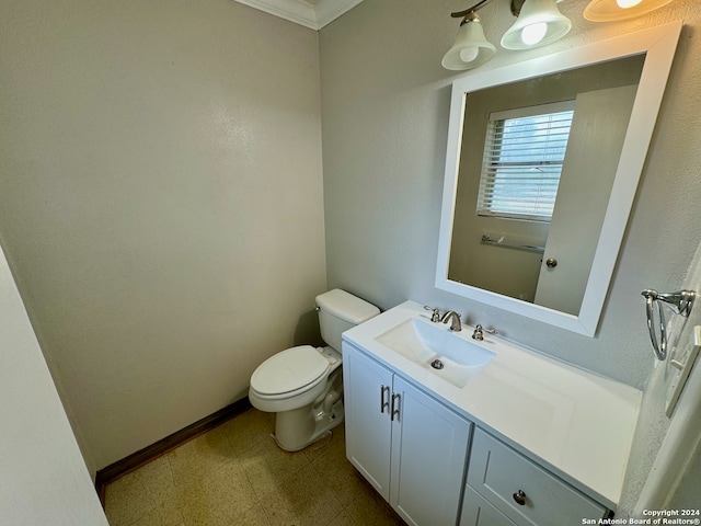 bathroom with ornamental molding, vanity, and toilet