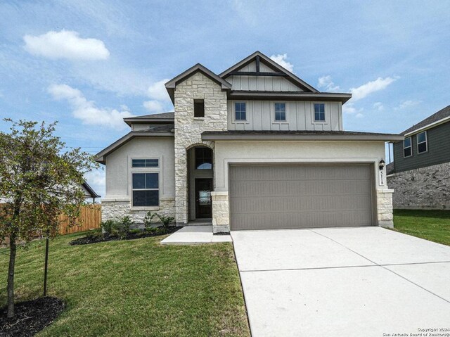 craftsman inspired home with a garage and a front lawn