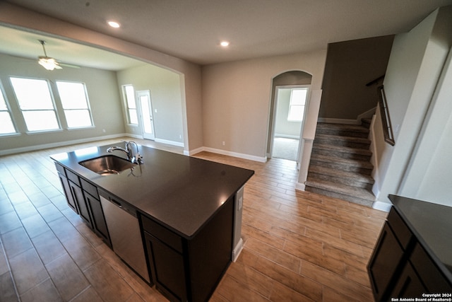 kitchen featuring a healthy amount of sunlight, light hardwood / wood-style floors, sink, and an island with sink