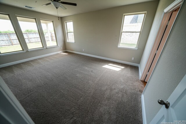 spare room with ceiling fan, carpet flooring, and a healthy amount of sunlight