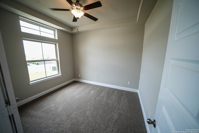 carpeted empty room with ceiling fan and plenty of natural light