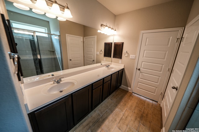 bathroom with hardwood / wood-style floors, a shower with door, and vanity