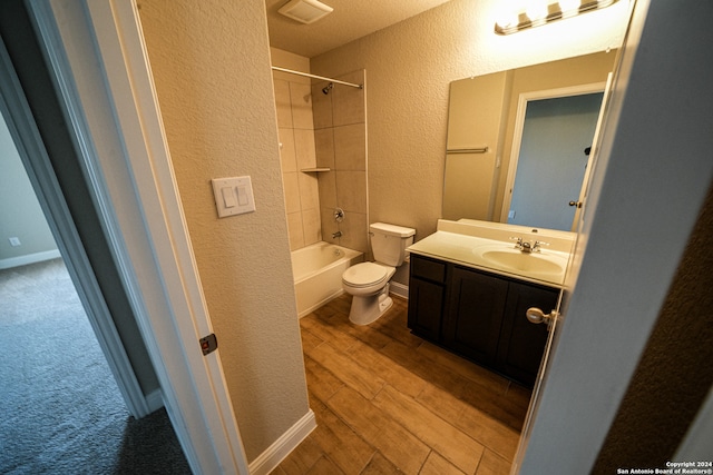 full bathroom featuring vanity, tiled shower / bath, toilet, and hardwood / wood-style floors