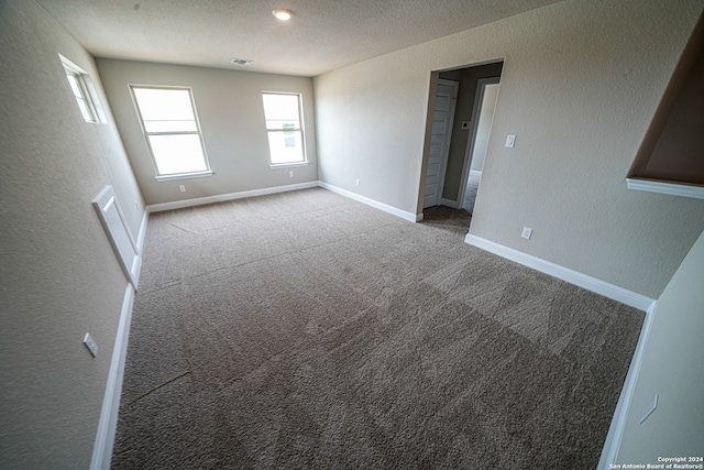 carpeted spare room featuring a textured ceiling