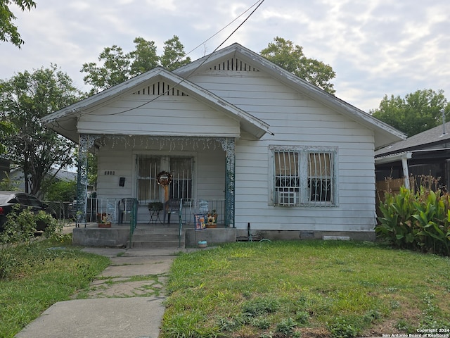 bungalow-style home with a front lawn and a porch