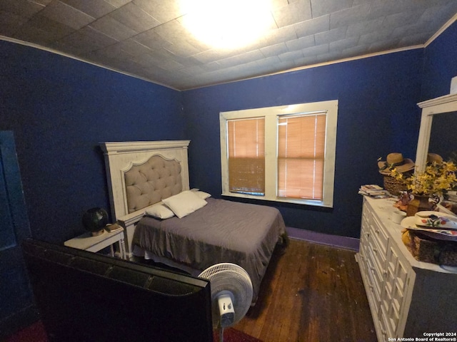 bedroom with ornamental molding and dark hardwood / wood-style flooring