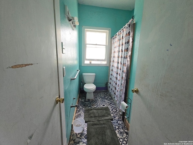 bathroom with walk in shower, tile patterned flooring, and toilet