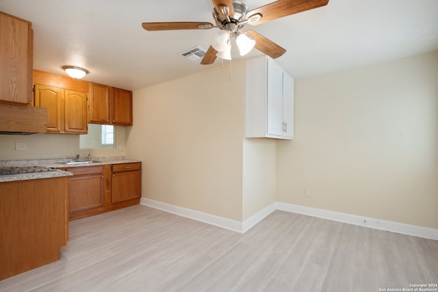 kitchen featuring ceiling fan, light wood-type flooring, and sink