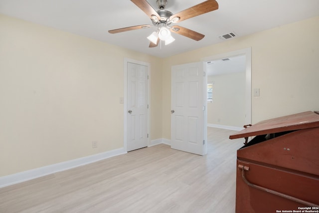 unfurnished bedroom with ceiling fan and light wood-type flooring