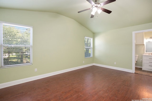 unfurnished bedroom with multiple windows, ensuite bathroom, ceiling fan, and dark hardwood / wood-style flooring