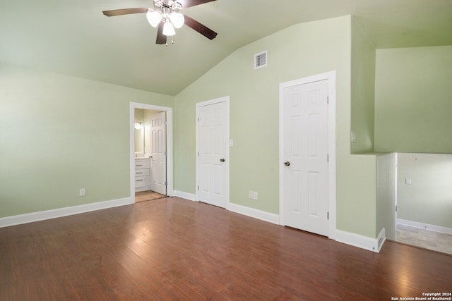 unfurnished bedroom with lofted ceiling, ceiling fan, dark wood-type flooring, and ensuite bathroom