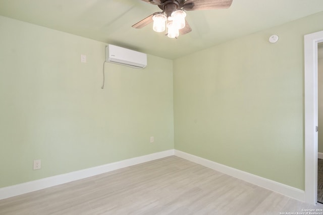 spare room with light hardwood / wood-style floors, ceiling fan, and a wall unit AC