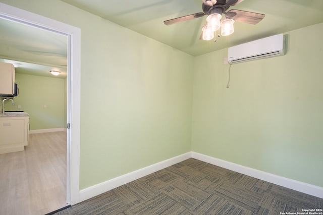 empty room with ceiling fan, hardwood / wood-style flooring, sink, and a wall mounted AC