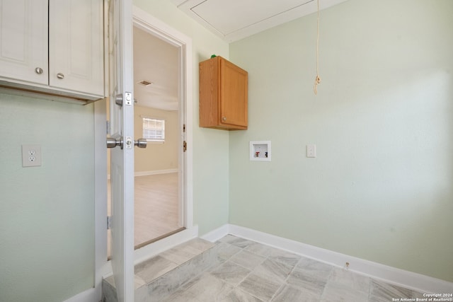 clothes washing area featuring washer hookup and cabinets