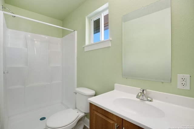 bathroom featuring walk in shower, vanity, and toilet