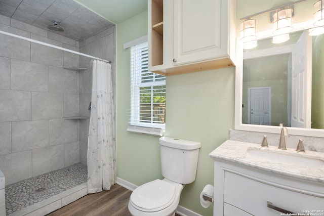 bathroom with walk in shower, vanity, toilet, and hardwood / wood-style flooring