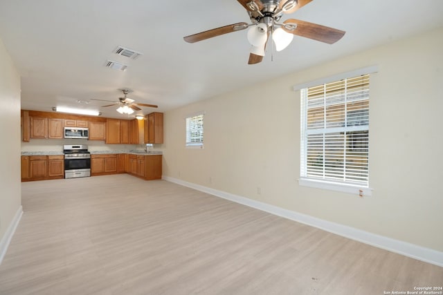 kitchen featuring ceiling fan, sink, stainless steel appliances, and light hardwood / wood-style floors