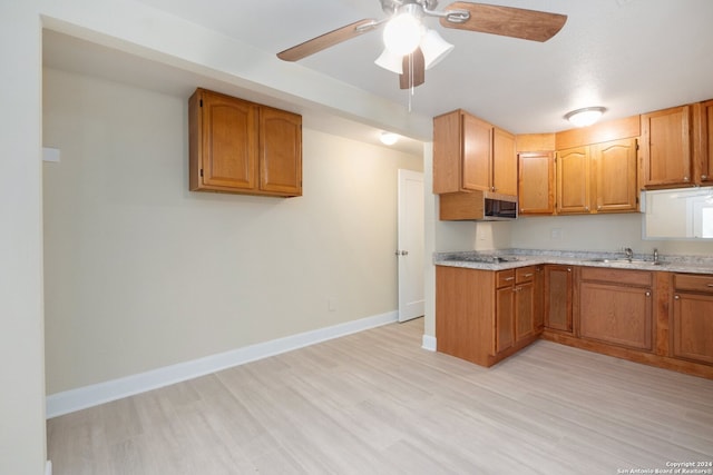 kitchen with sink, ceiling fan, and light hardwood / wood-style flooring