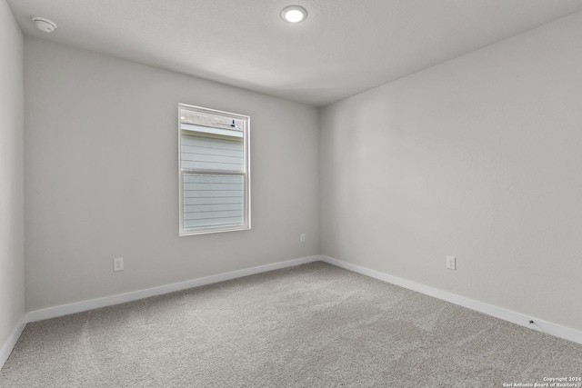 empty room featuring baseboards and carpet flooring