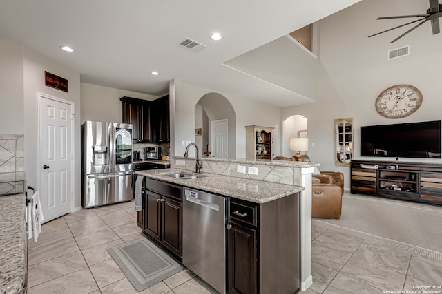 kitchen featuring dark brown cabinets, a kitchen island with sink, sink, appliances with stainless steel finishes, and ceiling fan