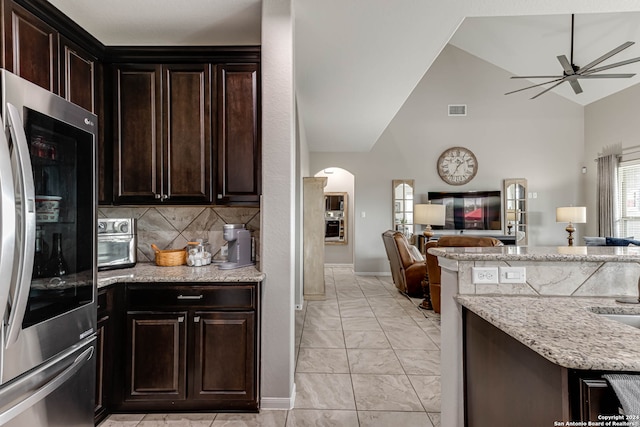 kitchen with stainless steel refrigerator, vaulted ceiling, dark brown cabinets, and ceiling fan