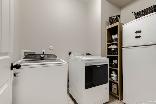 laundry room with separate washer and dryer and light tile patterned floors