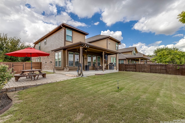 rear view of property featuring a lawn and a patio area