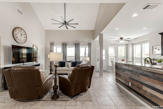 living room with lofted ceiling, light tile patterned flooring, and ceiling fan