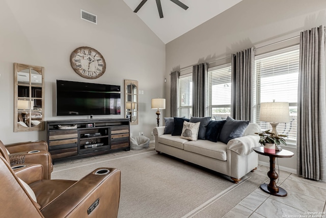 tiled living room with ceiling fan and high vaulted ceiling