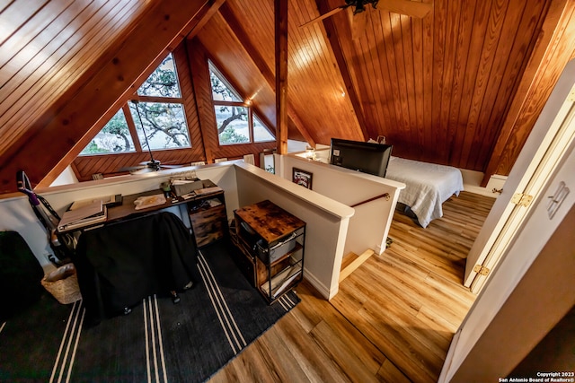 bedroom with lofted ceiling, wood ceiling, wooden walls, and light hardwood / wood-style floors