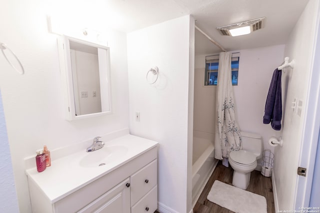 full bathroom with shower / tub combo with curtain, hardwood / wood-style flooring, vanity, and toilet