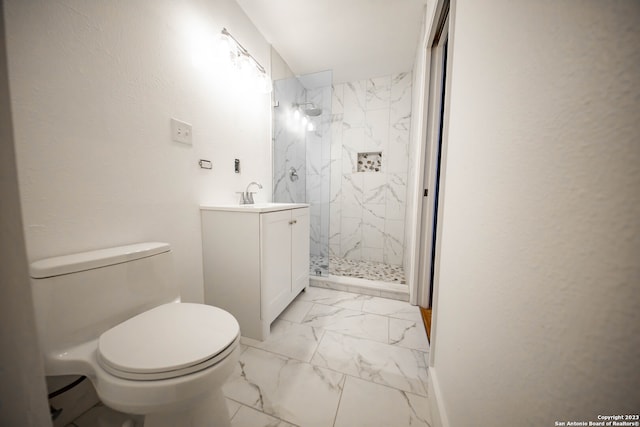 bathroom with vanity, toilet, and tiled shower