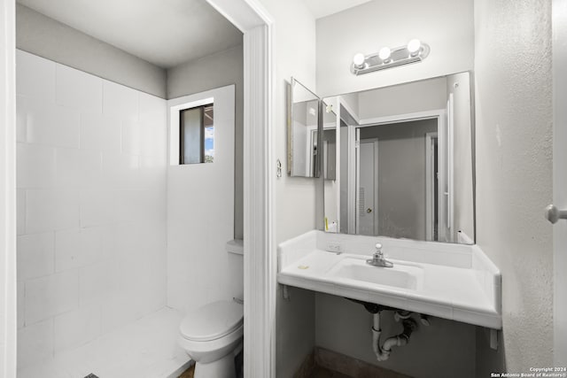 bathroom with tiled shower and toilet