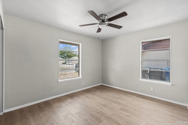 empty room with ceiling fan and light hardwood / wood-style floors